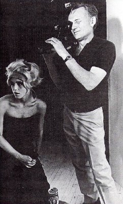 black-and-white photograph of Edie Sedgwick with a hair band and Ricky Leacock holding a camera. Filming scenes for Sarah Caldwell production of Lulu, August, 1967