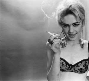 black-and-white photograph of Edie Sedgwick in a black bra and smoking a cigarette